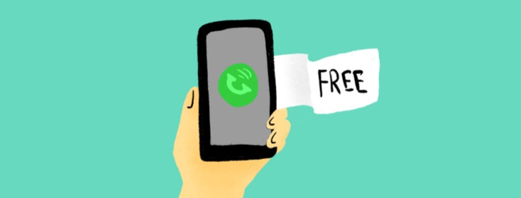 A hand holding a smart phone and the word "free" written on a piece of paper next to the phone