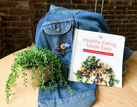 T2D cookbook and set of three pins on a denim jacket.
