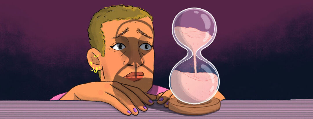 a woman stares at an hourglass