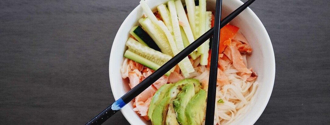 Noodle Salmon Bowl with chopsticks laid across the top of the white bowl.