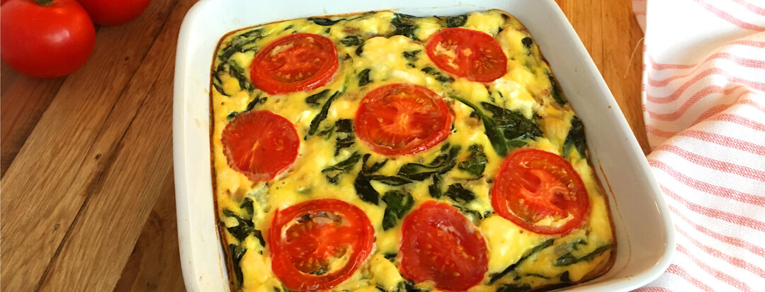 Dish on table with Spinach Feta and Tomato Egg Bake.