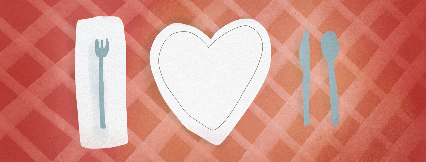 A heart-shaped plate on a tablecloth with silverware set on either side.